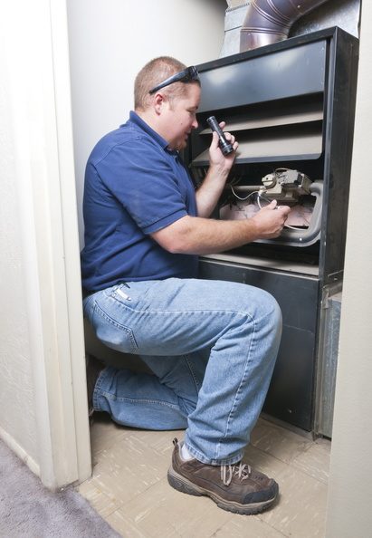 Technician repairing a home furnace
